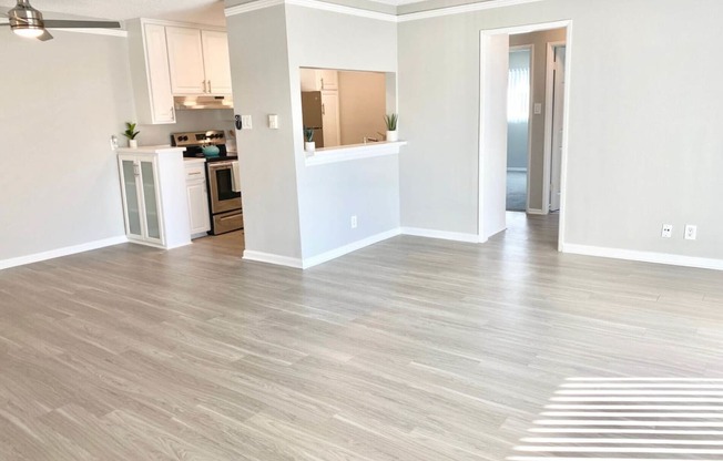an empty living room and kitchen with a wood floor at The Flats on Addison, Sherman Oaks, 91423