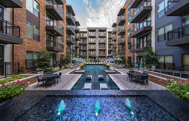 A fountain in the middle of a courtyard surrounded by buildings.