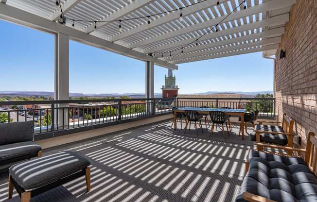 a covered patio with a table and chairs and a view of the city