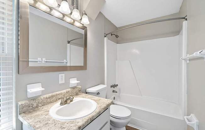 A bathroom with a sink, toilet, and shower.