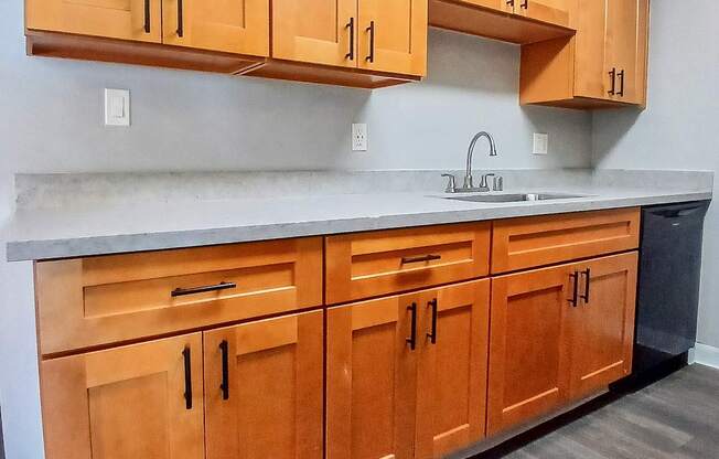 A kitchen with wooden cabinets and a sink.