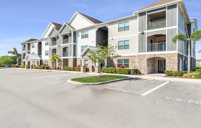 A large apartment complex with a parking lot in front.