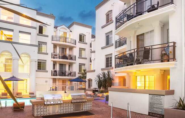 Dog-Friendly Apartments in Los Angeles, CA - The Preston - BBQ Grill Beside Pool with Jacuzzi and View of Apartment Buildings