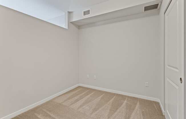 an empty room with carpet and a white door