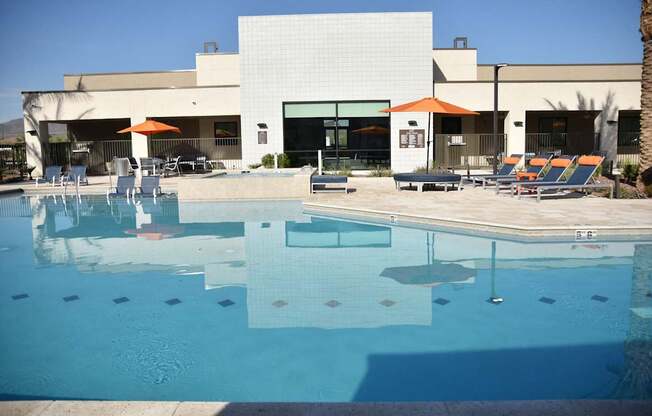 A swimming pool in front of a building with a white facade.