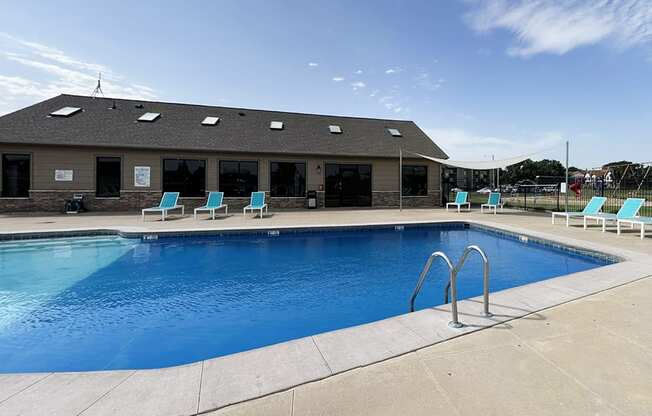 A large outdoor swimming pool with a building in the background.