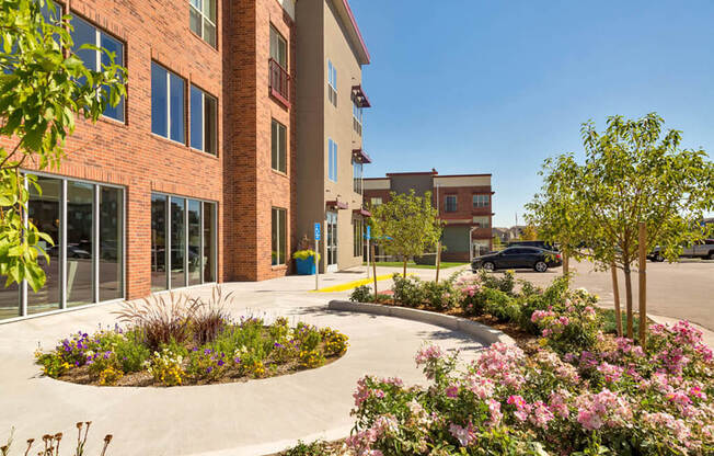 Westwood Green Leasing Office Entrance with round planter, flowers and trees