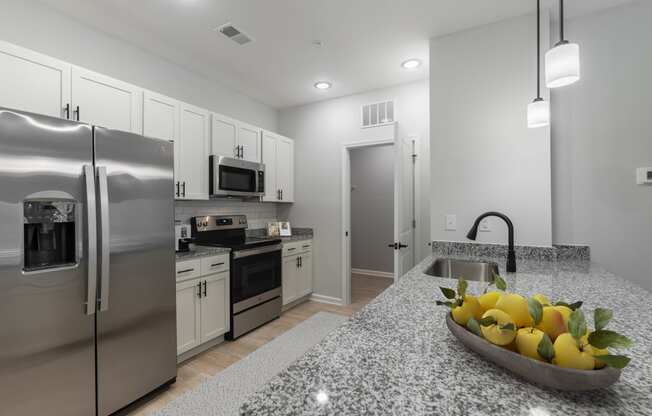 a kitchen with stainless steel appliances and a bowl of fruit