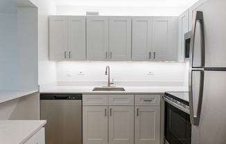 A kitchen with white cabinets and appliances.