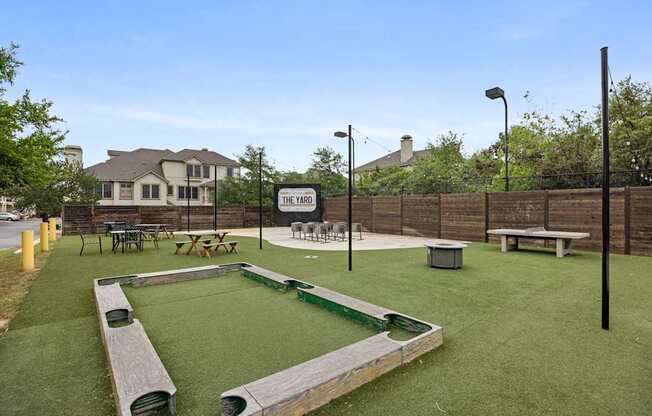 A playground with a green surface and a sign that says