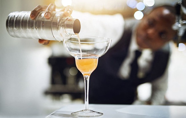 Bartender pouring a cocktail representing nearby bars and dining by Lux Apartments Bellevue