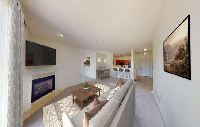 A living room with a grey couch and a flat screen TV mounted on the wall.