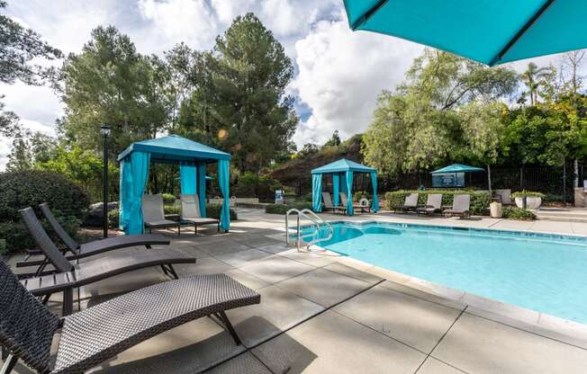 a swimming pool with chairs and umbrellas