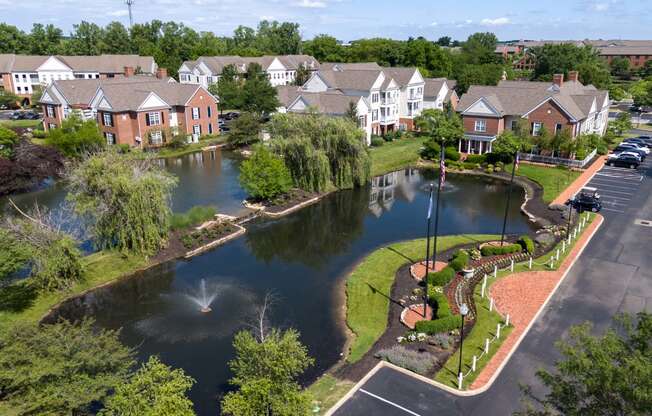 an aerial view of a pond with houses in the background