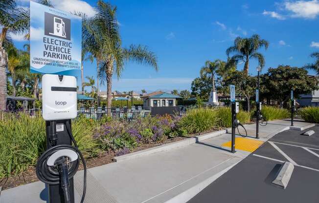 A sign for electric vehicle parking is displayed on a pole.