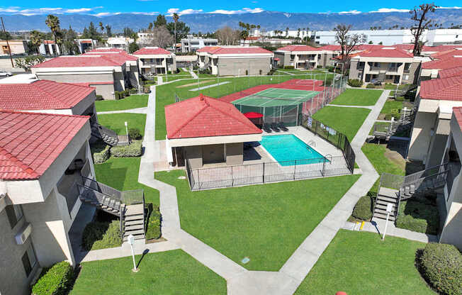 A view of a courtyard with a tennis court and a pool.