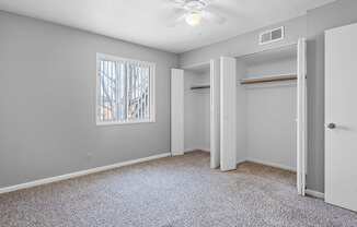 a bedroom with a ceiling fan and a window