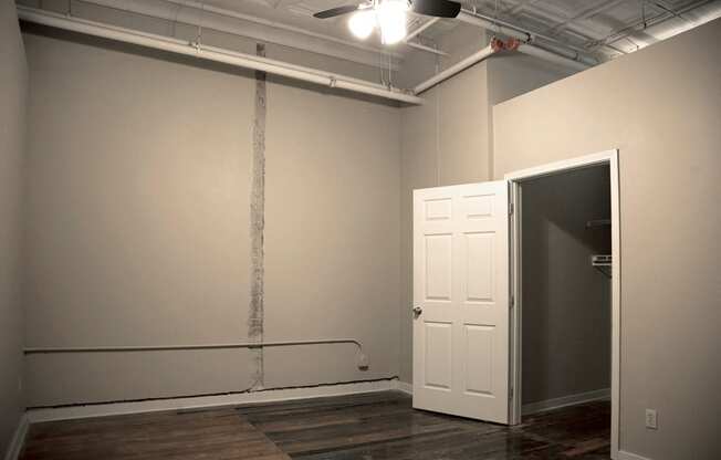 Large bedroom with ceiling fan and hardwood floors  at Fix Play Lofts, Birmingham, AL