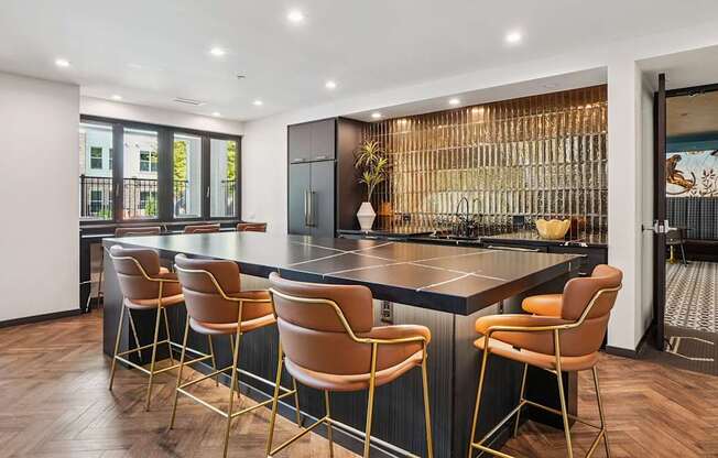 A modern kitchen with a bar area and chairs.