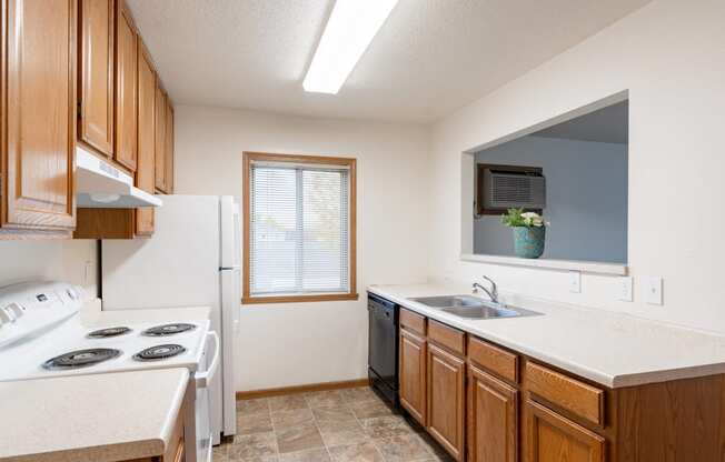 a kitchen with a stove sink and a refrigerator. Fargo, ND Oxford Apartments