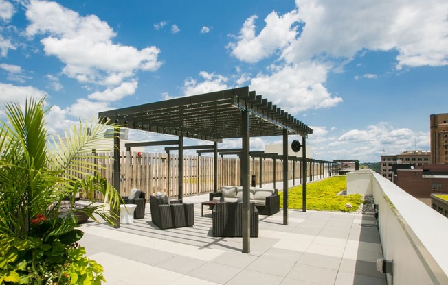 a roof terrace with tables and chairs and a pergola on a rooftop