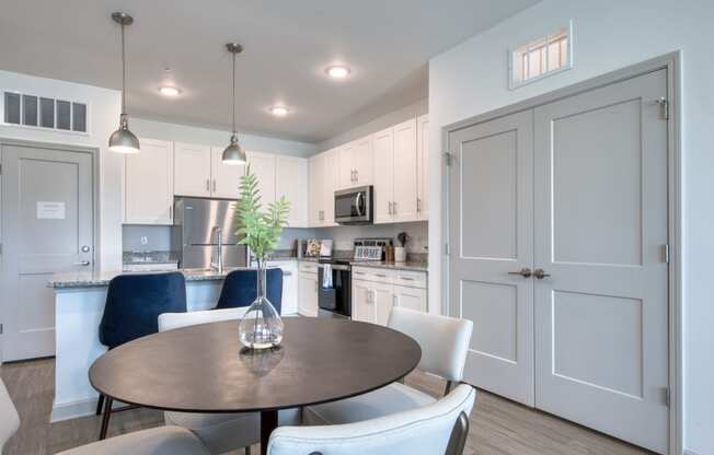 a kitchen and dining room with white cabinets and a table