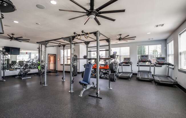 spacious gym with cardio equipment and windows at the district flats apartments