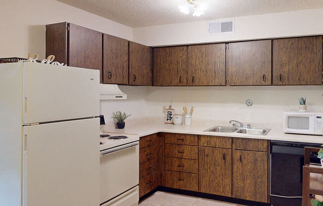 a kitchen with white appliances and wooden cabinets