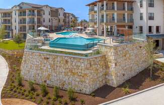 an aerial view of a pool with an apartment building in the background