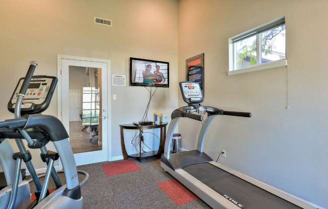 the gym has a treadmill and a tv