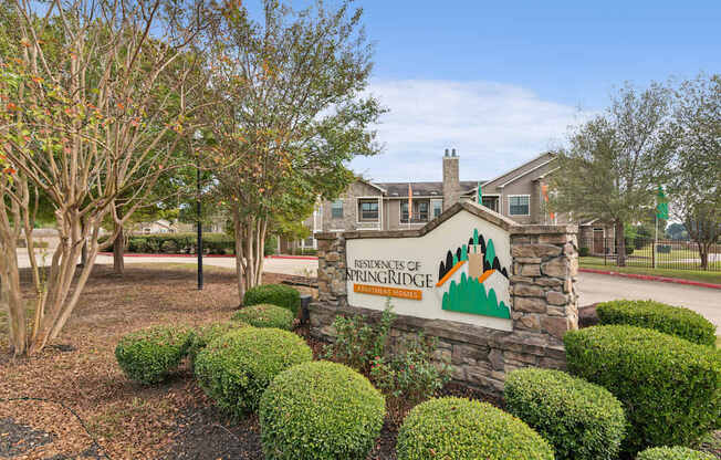 A sign for the residents of Springridge in front of a building and trees.
