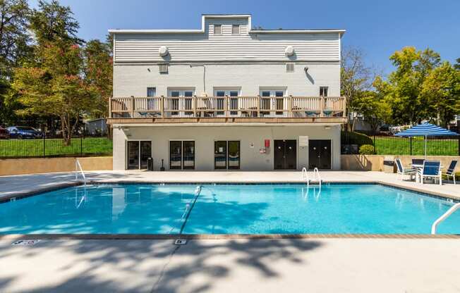 a swimming pool in front of a house with a pool