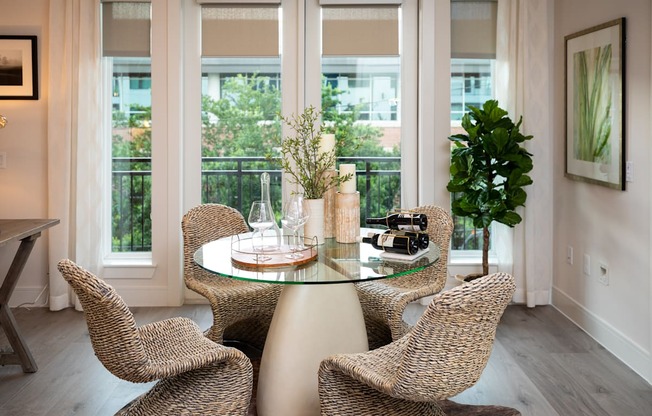 A glass table with four chairs around it.