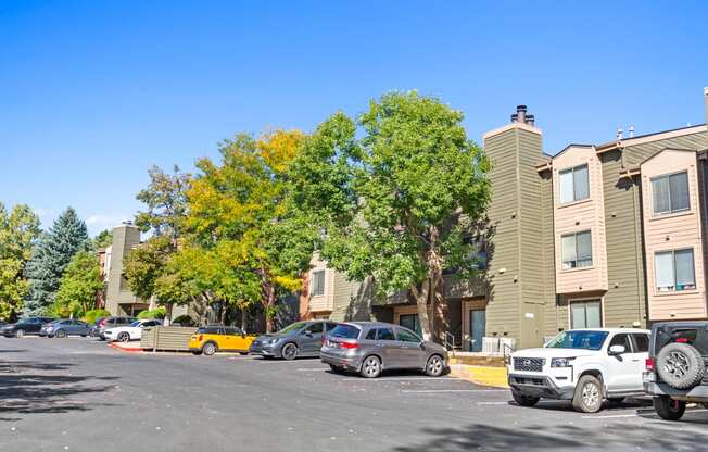 a parking lot with cars in front of an apartment building