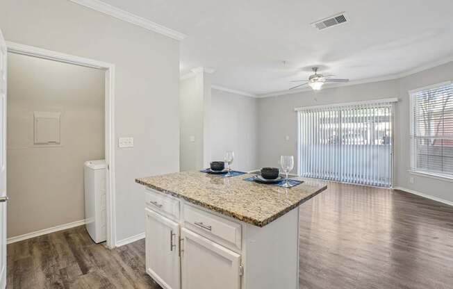 A kitchen with granite countertops and white cabinets.