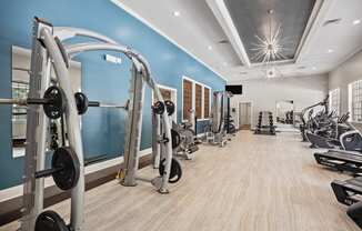 a gym with weights and other exercise equipment and a light blue wall