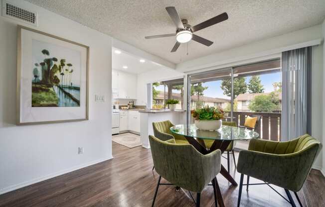 a dining area with a table and chairs and a ceiling fan