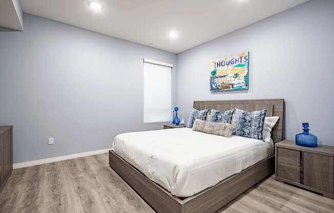 Bedroom with recessed lighting, laminate flooring, window with solar blinds on the left