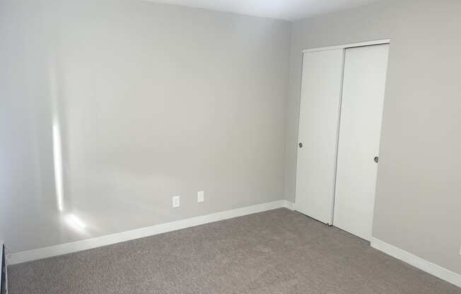 an empty room with a carpet and a door