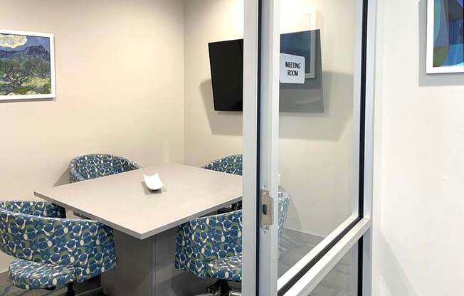 A meeting room with a table and chairs.