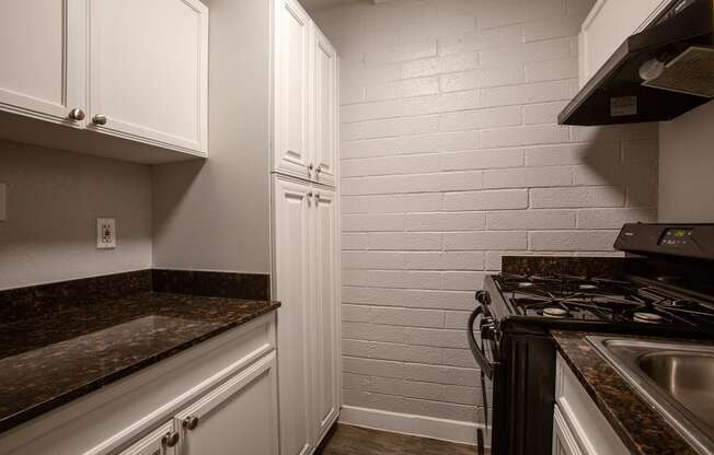 a kitchen with white cabinets and a stove and a sink