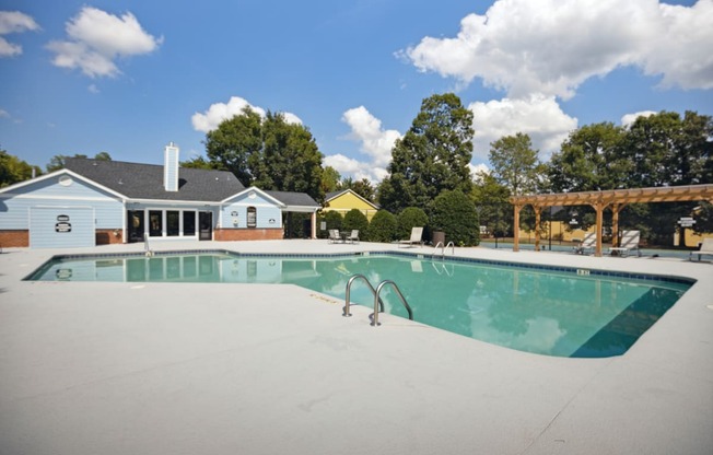 a swimming pool with a house in the background