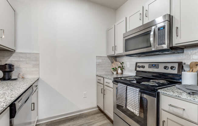 A kitchen with a stove, oven, and microwave.