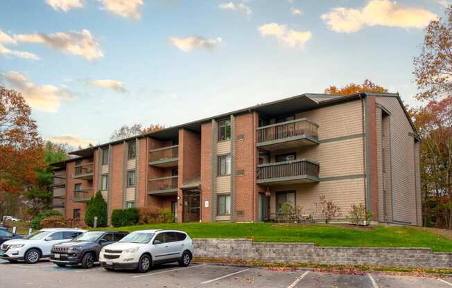 an apartment building with cars parked in a parking lot