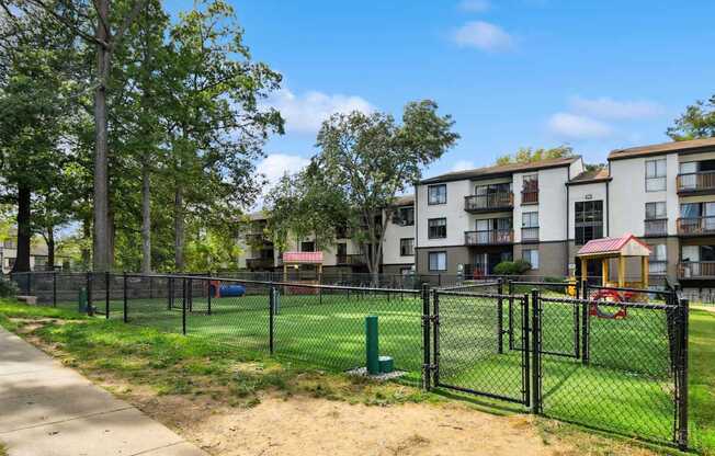 A black fence surrounds a playground in a residential area.