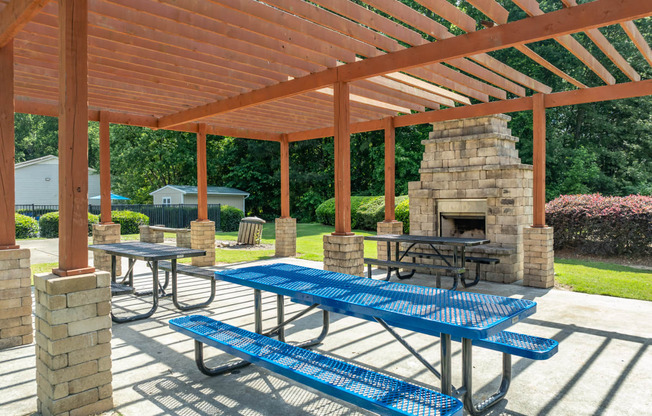 a picnic pavilion with benches and a stone fireplace