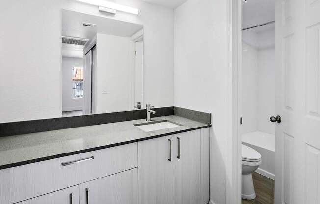 A white bathroom with a sink and toilet.