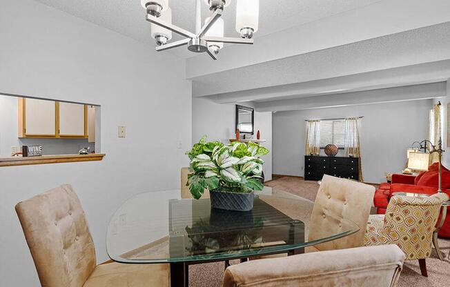 a living room with a glass table and chairs