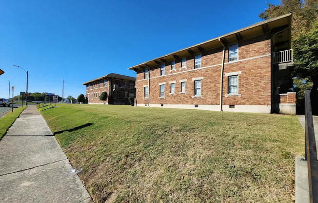 A brick building with a green lawn in front.
