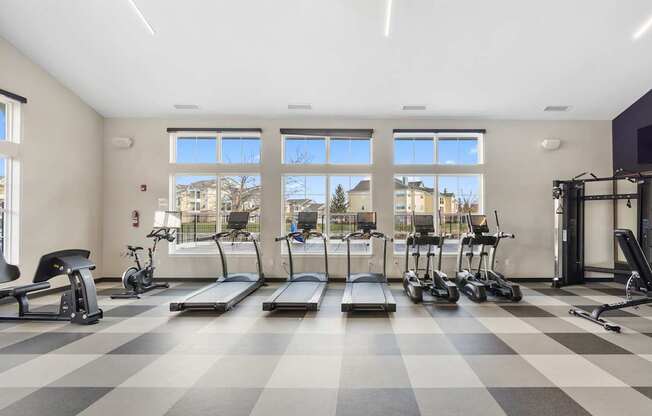 A gym with treadmills, exercise bikes, and other equipment.